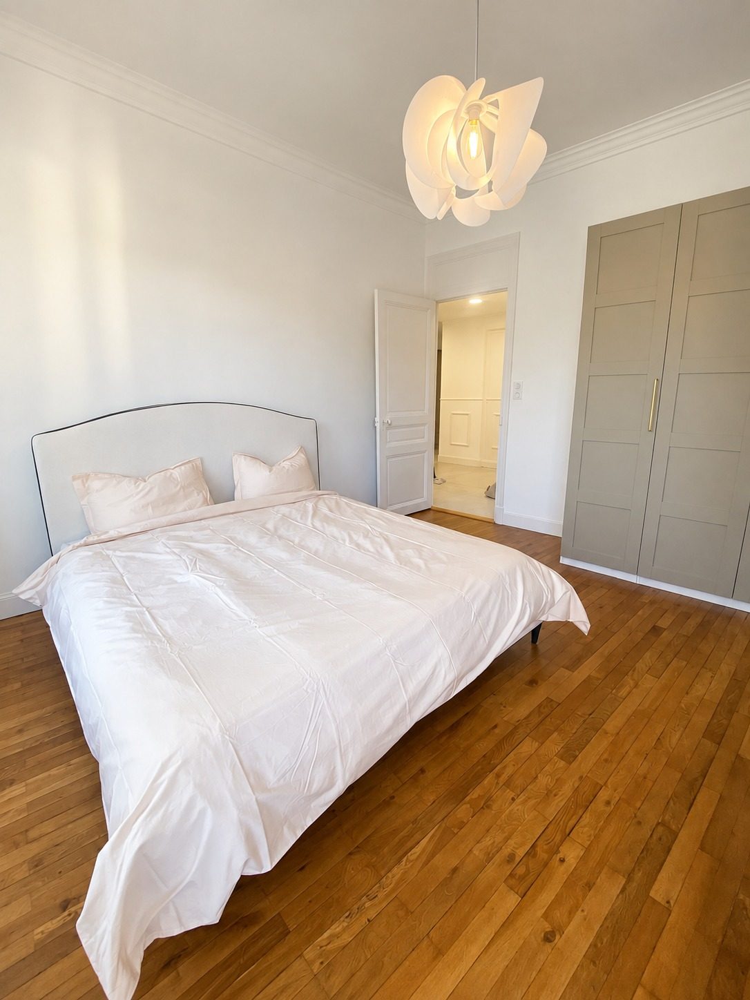 Dal letto, l'infilata fino al corridoio: cornice di soffitto, mostre laccate e parquet di rovere da una stanza all'altra.