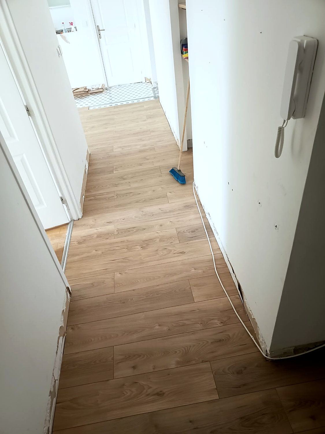 Le câble de l'interphone est laissé en attente le long du mur : il passera derrière la plinthe, sans saignée ni goulotte.