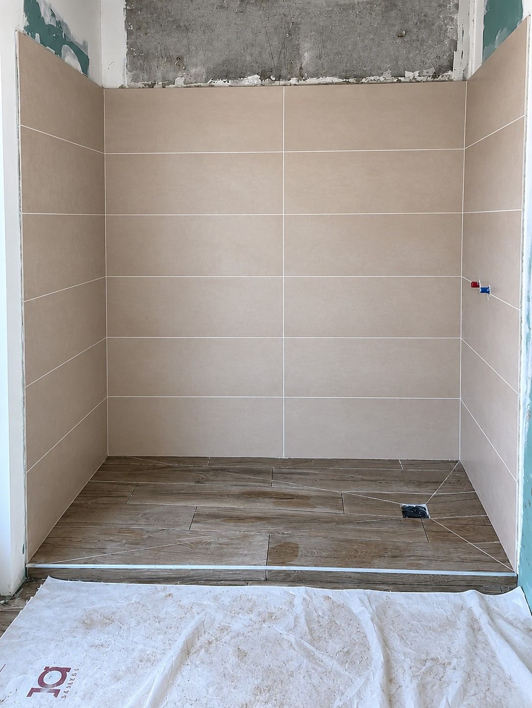 Receveur extra-plat, sol imitation bois poursuivi jusque dans la douche.